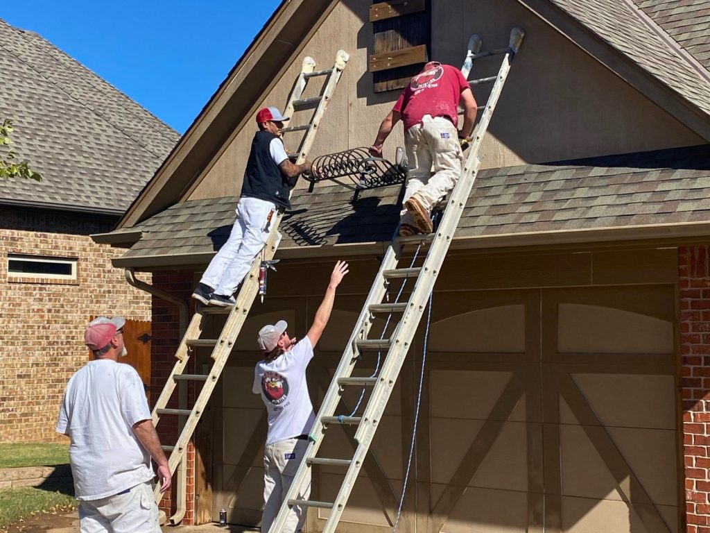 Cardinal Painting crew members painting exterior trim and siding from ladders
