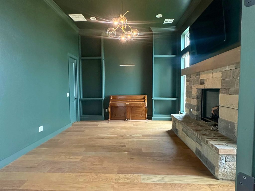Unfinished residential interior with painted teal walls and exposed construction materials
