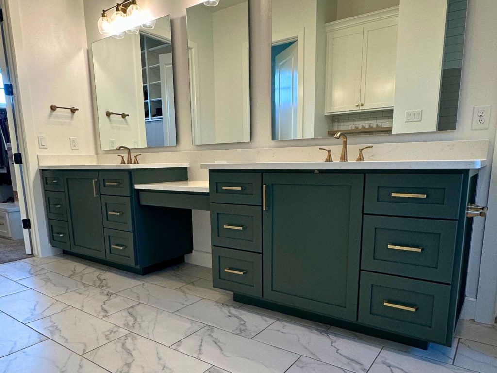 Kitchen with dark green painted cabinets, white countertops and light-colored walls